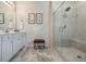 Bright bathroom featuring a glass shower, gray tile flooring, and a white double sink vanity at 4870 Odum View Ln, Cumming, GA 30040