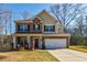 Charming two-story home with a well-maintained lawn, brick facade, and inviting front porch at 4870 Odum View Ln, Cumming, GA 30040