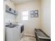 Functional laundry room with washer, dryer, shelving, and a decorative storage basket at 4870 Odum View Ln, Cumming, GA 30040