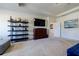 Bright main bedroom featuring modern shelving, a TV over a handsome dresser, and neutral carpeting at 4870 Odum View Ln, Cumming, GA 30040