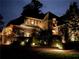 Exterior home elevation at night with beautiful landscape lighting and manicured shrubs at 710 E Northway Ln, Atlanta, GA 30342