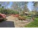 Stone patio with outdoor dining area and fire pit, surrounded by lush landscaping at 710 E Northway Ln, Atlanta, GA 30342