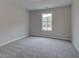 Neutral carpeted bedroom illuminated by natural light from a single window at 1628 Ruskin Way, Marietta, GA 30062