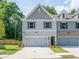 Charming townhome featuring a two-car garage, gray siding, and manicured lawn at 1628 Ruskin Way, Marietta, GA 30062