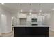 Modern kitchen featuring a dark island, white cabinets, and updated lighting at 1628 Ruskin Way, Marietta, GA 30062