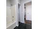 This bathroom features a tub with shower, black and white tiled floors, and entry to hallway at 2601 Semmes St, Atlanta, GA 30344