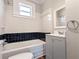 Clean bathroom features black and white tiled walls, tub with shower, and vanity at 2601 Semmes St, Atlanta, GA 30344