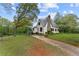 View of home with a side deck and a stone chimney on a large lawn at 2601 Semmes St, Atlanta, GA 30344