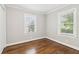 Empty bedroom featuring hardwood floors, white trim, baseboards, and two bright windows at 353 Oak Ridge Se Dr, Marietta, GA 30060