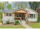 Charming home featuring a covered porch, lush lawn, fresh white siding, and detailed window trim at 353 Oak Ridge Se Dr, Marietta, GA 30060