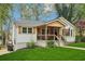 Charming home featuring a covered porch, lush lawn, fresh white siding, and detailed window trim at 353 Oak Ridge Se Dr, Marietta, GA 30060