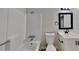 Bright bathroom features a white sink, vanity, toilet and tub/shower combo, complemented by modern black accents at 4805 Kellys Mill Nw Dr, Lilburn, GA 30047