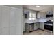 Modern kitchen featuring gray cabinetry, stainless steel appliances, subway tile backsplash, and laminate flooring at 4805 Kellys Mill Nw Dr, Lilburn, GA 30047