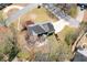A lush, green property featuring a two-story house, mature trees, and a circular patio area at 966 Laurel Springs Sw Ln, Marietta, GA 30064