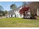Charming two-story white brick home on a sunny day with well-manicured lawn, tree with red leaves at 966 Laurel Springs Sw Ln, Marietta, GA 30064