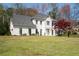 A charming two-story home with a well-manicured lawn, a tree with red leaves and white brick at 966 Laurel Springs Sw Ln, Marietta, GA 30064