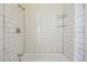 Clean and modern bathroom shower featuring white subway tiles and glass shelving, with chrome plumbing fixtures at 2391 Cove Rd, Lithonia, GA 30058