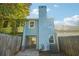 Exterior view of the home featuring a fenced yard, a rear patio, and a light blue siding at 2391 Cove Rd, Lithonia, GA 30058