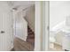 Bright hallway featuring wood-look floors, a staircase, and a view into the first-floor powder room at 2391 Cove Rd, Lithonia, GA 30058
