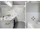 Bright bathroom featuring dual vanity sinks, a soaking tub, and tiled floors at 2650 Hamilton Chase Run, Buford, GA 30519