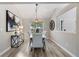 Dining room with wood-look floors, a modern light fixture, and white upholstered chairs at 2650 Hamilton Chase Run, Buford, GA 30519
