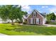Well-manicured lawn and landscaping accent this charming brick two-story home with black shutters at 2650 Hamilton Chase Run, Buford, GA 30519