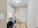 Well-lit laundry room with modern washer and dryer, white cabinets and convenient utility sink at 2650 Hamilton Chase Run, Buford, GA 30519