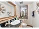 Charming powder room with decorative mirror, patterned wallpaper, and unique sink accessories at 2720 Cold Springs Sw Trl, Marietta, GA 30064