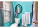 Bright bathroom with blue walls, a round mirror, window with blinds and white towels at 2720 Cold Springs Sw Trl, Marietta, GA 30064