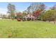 Home exterior with large front yard featuring mature trees and bushes at 2720 Cold Springs Sw Trl, Marietta, GA 30064