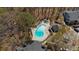 Aerial shot of a sparkling blue community pool surrounded by lush trees and a well maintained pool deck area at 409 Natchez Trce, Sandy Springs, GA 30350