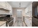 Galley kitchen boasts white cabinets, stainless steel appliances, subway tile backsplash, and modern countertops at 409 Natchez Trce, Sandy Springs, GA 30350