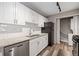 Bright kitchen features white cabinets, granite countertops, stainless steel appliances, and a laundry closet at 409 Natchez Trce, Sandy Springs, GA 30350