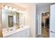 Bathroom with double sinks, a large mirror, and a walk-in shower at 904 Magnolia Leaf Dr, Woodstock, GA 30188