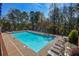 A large community pool is surrounded by lounge chairs and tables under a blue sky at 904 Magnolia Leaf Dr, Woodstock, GA 30188