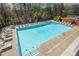 A community pool area shows lounge chairs and tables, as well as mature trees beyond at 904 Magnolia Leaf Dr, Woodstock, GA 30188