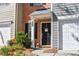 Charming townhome features a brick front porch with black front door and white trim at 904 Magnolia Leaf Dr, Woodstock, GA 30188