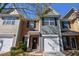 Traditional two-story townhome shows brick and siding, front door and garage under a blue sky at 904 Magnolia Leaf Dr, Woodstock, GA 30188