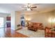 Inviting living room with hardwood floors, a ceiling fan, and a view into the adjacent kitchen at 904 Magnolia Leaf Dr, Woodstock, GA 30188