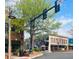 A charming street view showcasing local shops, with a tall green tree providing shade on a beautiful sunny day at 904 Magnolia Leaf Dr, Woodstock, GA 30188