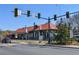 A picturesque building with a red tiled roof near a street intersection, surrounded by lush greenery and clear blue skies at 904 Magnolia Leaf Dr, Woodstock, GA 30188