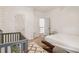 Bright bedroom with a wooden bed frame, geometric rug, crib, and natural light at 1085 Grace Hadaway Ln, Lawrenceville, GA 30043