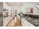 Well-lit kitchen featuring white cabinets, black granite countertops, and hardwood floors at 1085 Grace Hadaway Ln, Lawrenceville, GA 30043