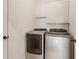 Functional laundry room with modern washer and dryer units, and overhead cabinets at 1085 Grace Hadaway Ln, Lawrenceville, GA 30043