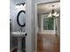 Powder room featuring a pedestal sink, round mirror, and view into a living room at 1514 Haven Crest Dr, Powder Springs, GA 30127