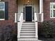Close-up of a home's entrance with a classic dark wood door and white railing at 1514 Haven Crest Dr, Powder Springs, GA 30127