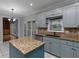 Bright kitchen with blue cabinets, granite countertops and island, and stainless steel dishwasher at 1514 Haven Crest Dr, Powder Springs, GA 30127