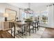 Bright dining room boasts ample windows, a modern chandelier, and stylish furniture arrangement at 2550 Bertrand Way, Cumming, GA 30041