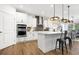 Bright kitchen featuring stainless steel appliances, white cabinetry, stylish lighting, and a central island at 2550 Bertrand Way, Cumming, GA 30041