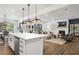 Open-concept living space featuring a modern kitchen, cozy living room with fireplace, and bright dining area at 2550 Bertrand Way, Cumming, GA 30041